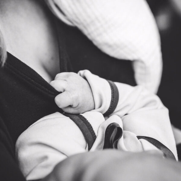 baby tugging at mother's shirt