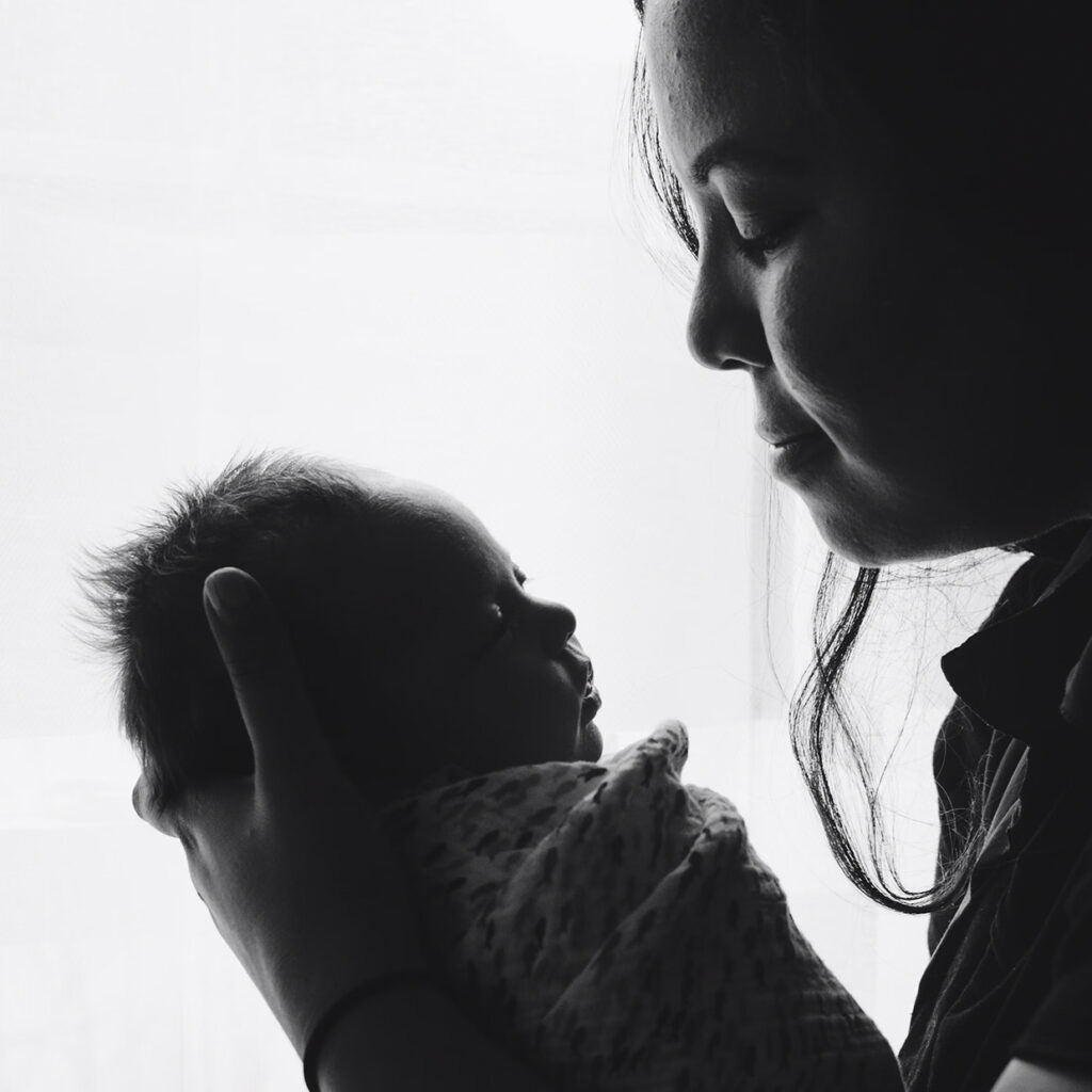 woman holding a swaddled newborn