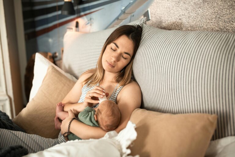 Mother sleeping with baby in her arms